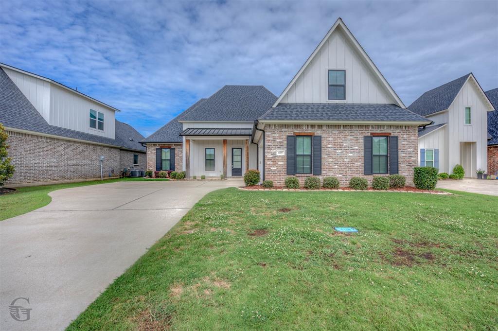 605 Meridian Way Benton, LA 71006 - Photo 2 of 29 Contemporary-style residence featuring a brick facade with vertical siding accents and a dark shingle roof