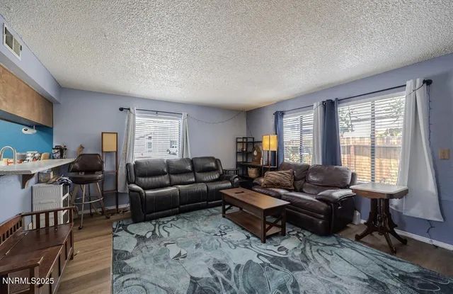 a living room with furniture wooden floor and a window