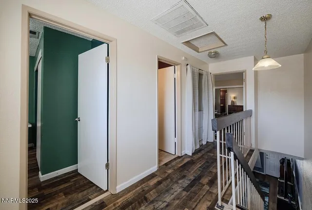 a view of a hallway with wooden floor and windows