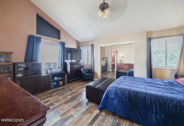 a spacious bedroom with a bed and wooden floor