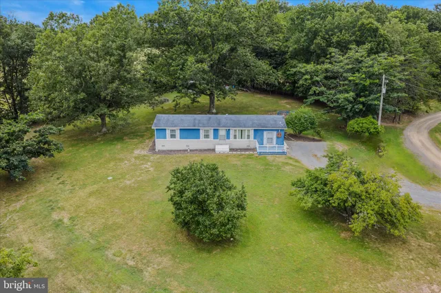 an aerial view of residential house with outdoor space and trees all around
