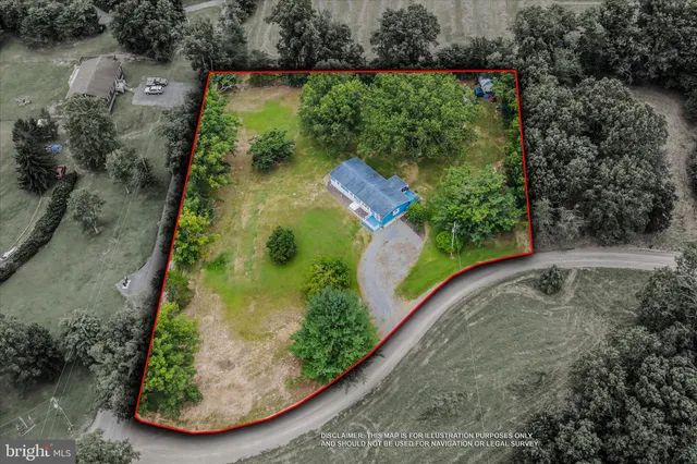 an aerial view of residential house with outdoor space and trees all around