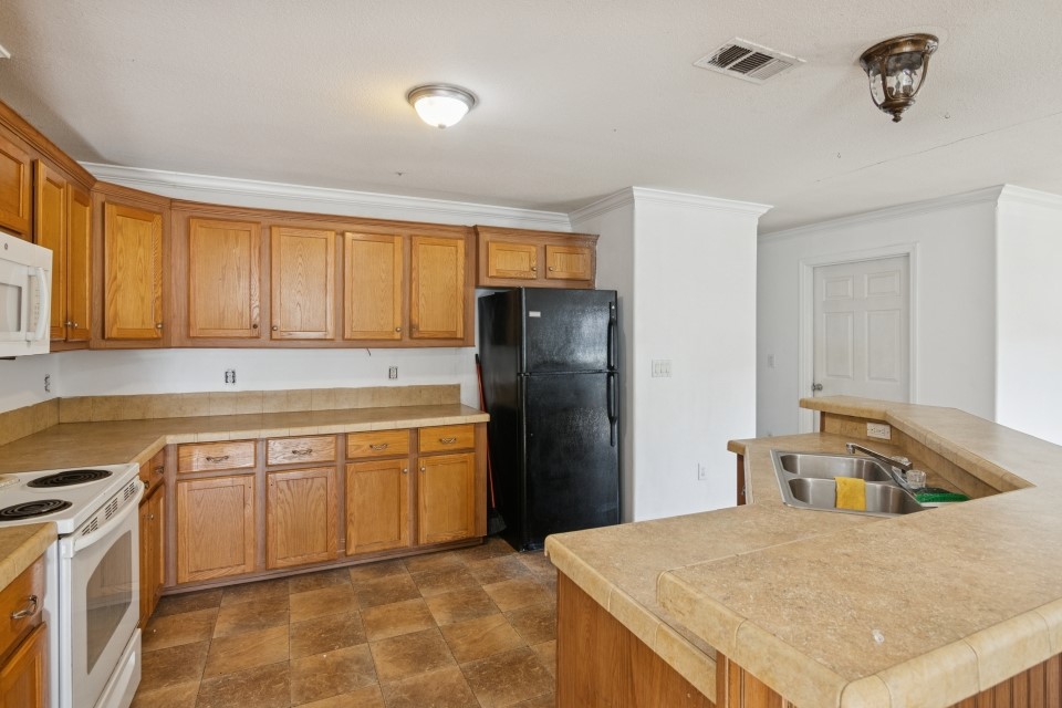 4619 2nd Street Bacliff, TX 77518 - Photo 12 of 24 a kitchen with a refrigerator sink and cabinets