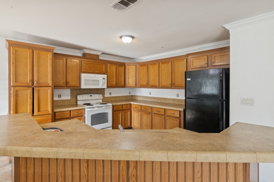 4619 2nd Street Bacliff, TX 77518 - Photo 13 of 24 a kitchen with a refrigerator a stove top oven and a refrigerator