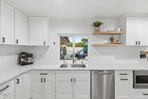 a kitchen with stainless steel appliances a white cabinets sink and stove