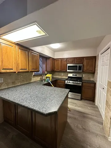 a kitchen with stainless steel appliances granite countertop a sink stove and refrigerator
