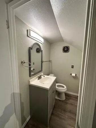 a bathroom with a toilet sink and mirror