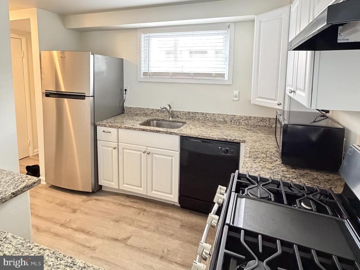 5485 Harpers Farm Road, Unit L3 Columbia, MD 21044 - Photo 5 of 24 a kitchen with a refrigerator and a stove