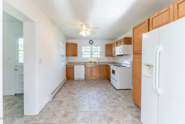 a kitchen with white cabinets and white appliances
