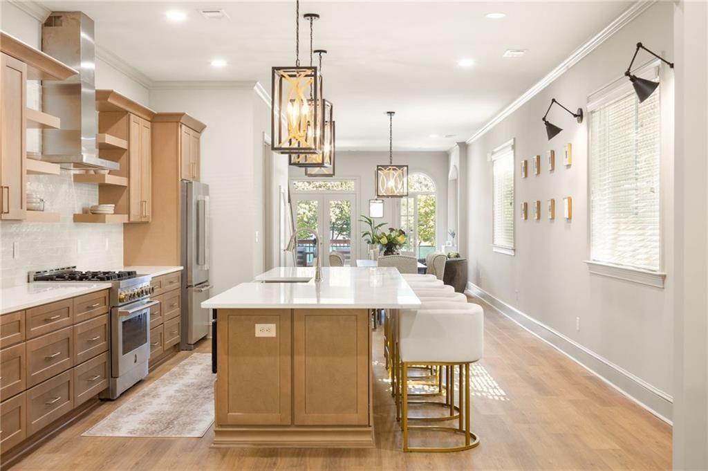 722 Lakeview Avenue Northeast, Unit A Atlanta, GA 30308 - Photo 2 of 48 a large kitchen with stainless steel appliances kitchen island granite countertop a table chairs and a refrigerator