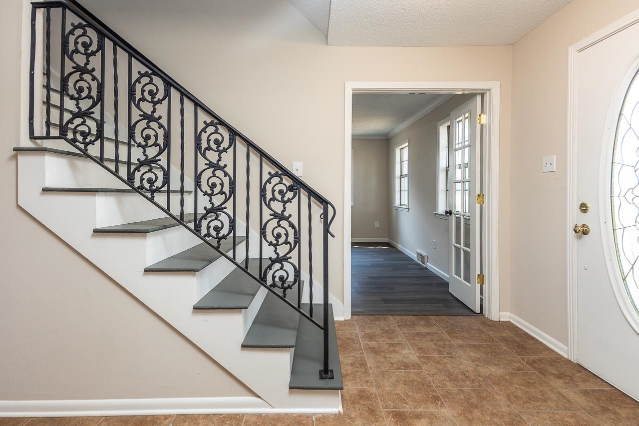 2718 Kate Bond Road Memphis, TN 38133 - Photo 14 of 39 a view of wooden staircase with a metal railing and a chandelier