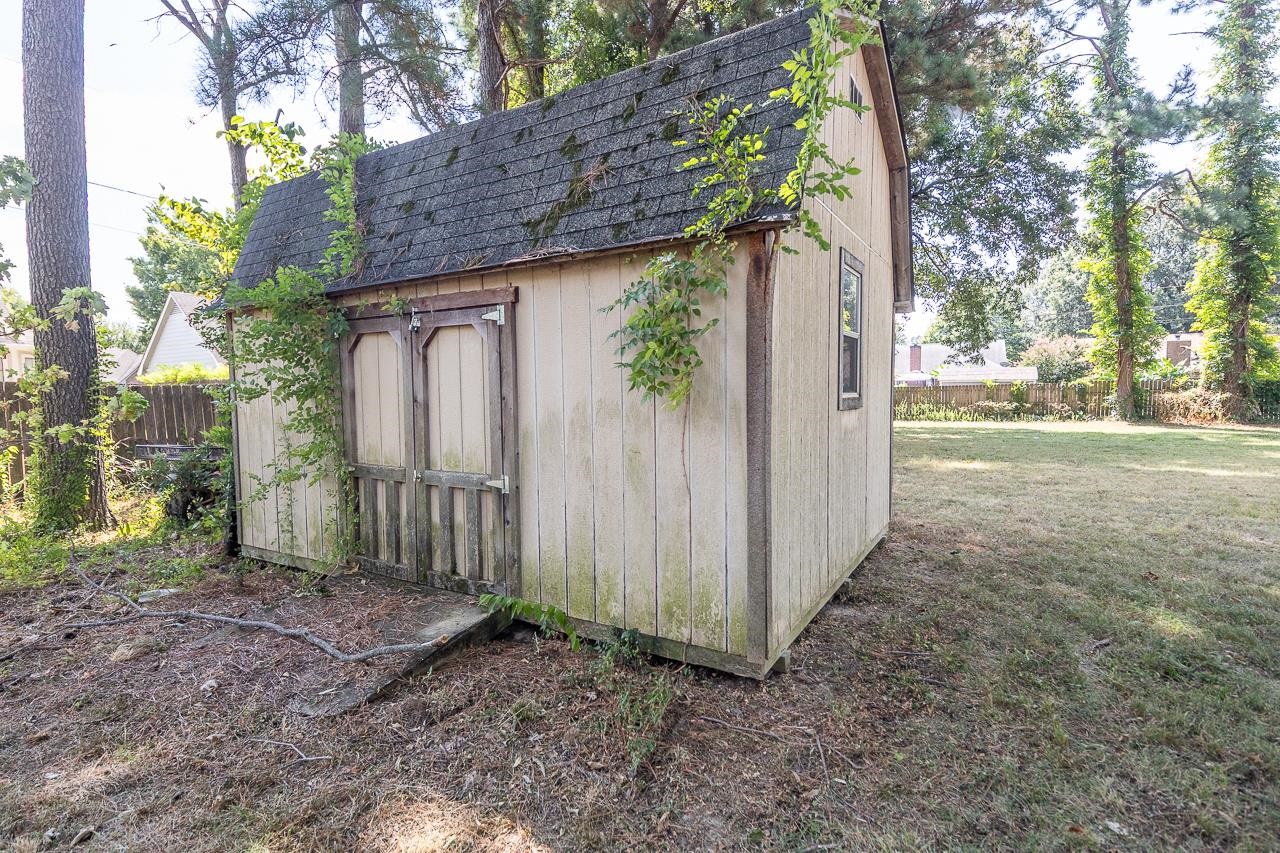 2718 Kate Bond Road Memphis, TN 38133 - Photo 32 of 39 a backyard of a house with large trees and wooden fence