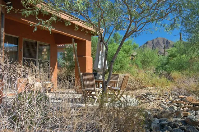a view of a chairs and table in the backyard of the house