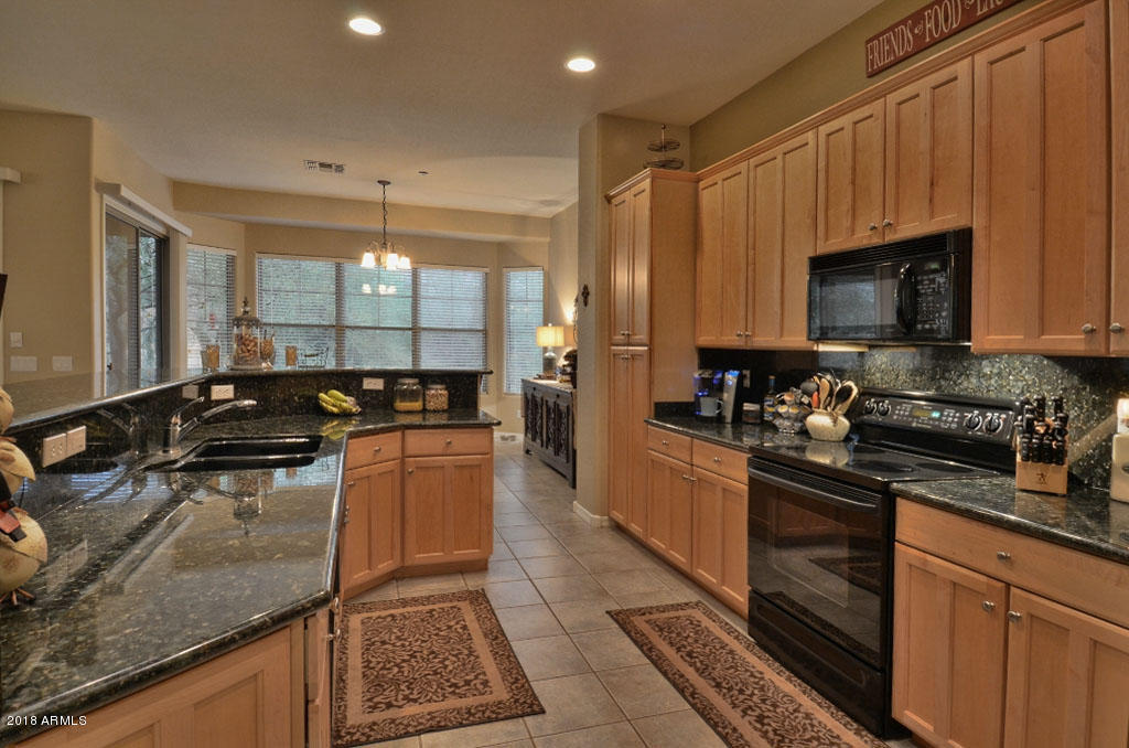 11475 East Helm Drive Scottsdale, AZ 85255 - Photo 7 of 35 a kitchen with stainless steel appliances granite countertop a stove a sink and a microwave