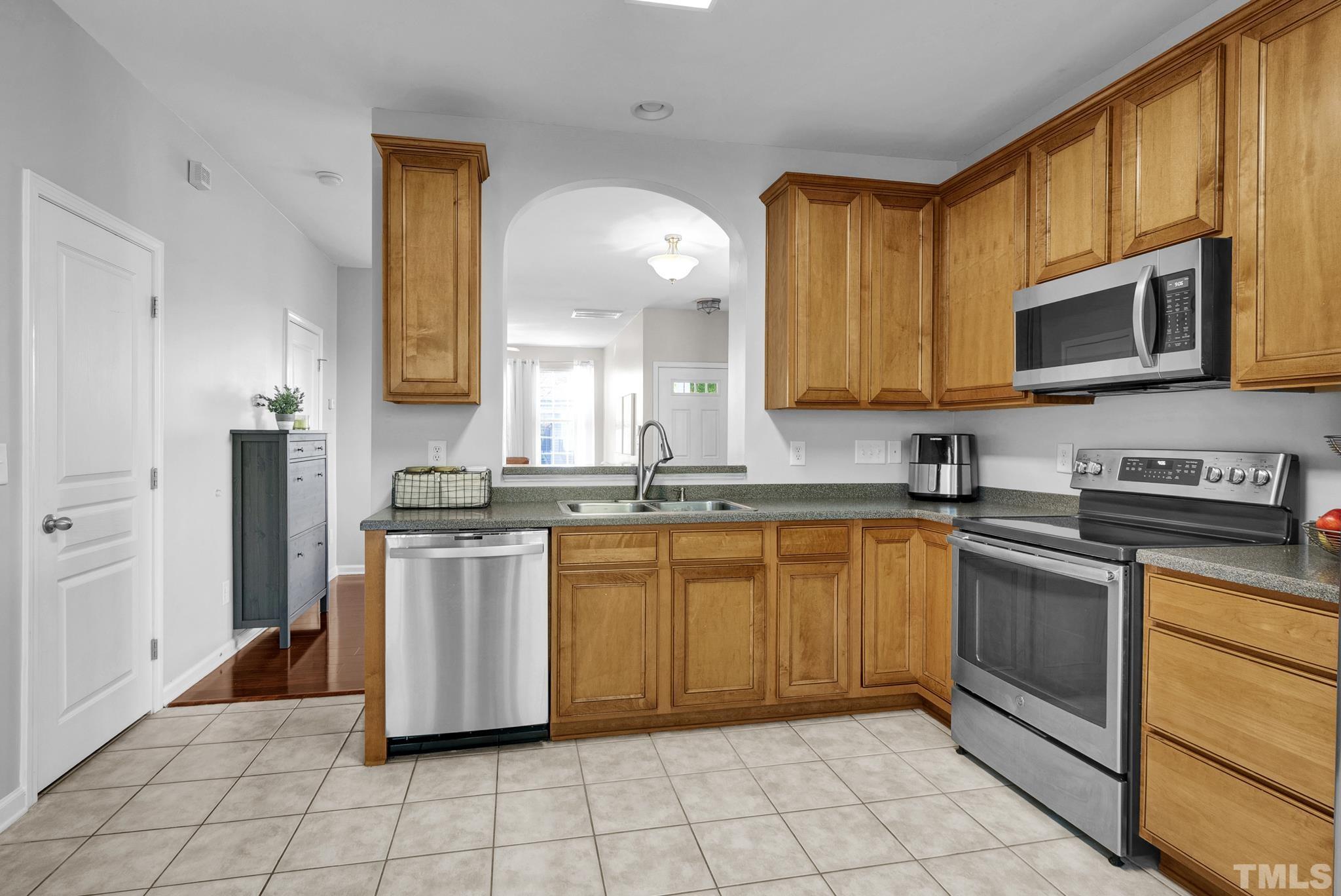 7618 Winners Edge Street Raleigh, NC 27617 - Photo 11 of 22 a kitchen with stainless steel appliances granite countertop a stove a sink and a microwave