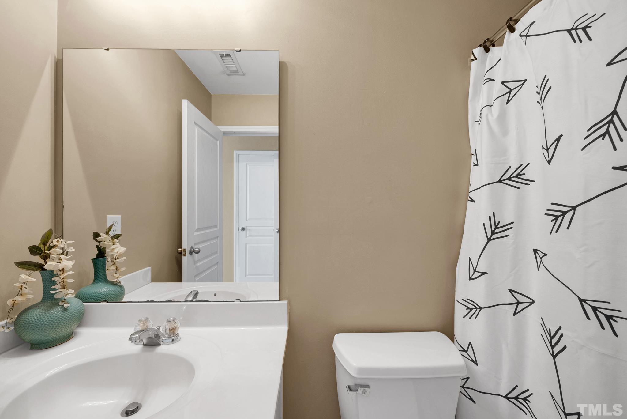 7618 Winners Edge Street Raleigh, NC 27617 - Photo 18 of 22 a bathroom with a sink and mirror with toilet