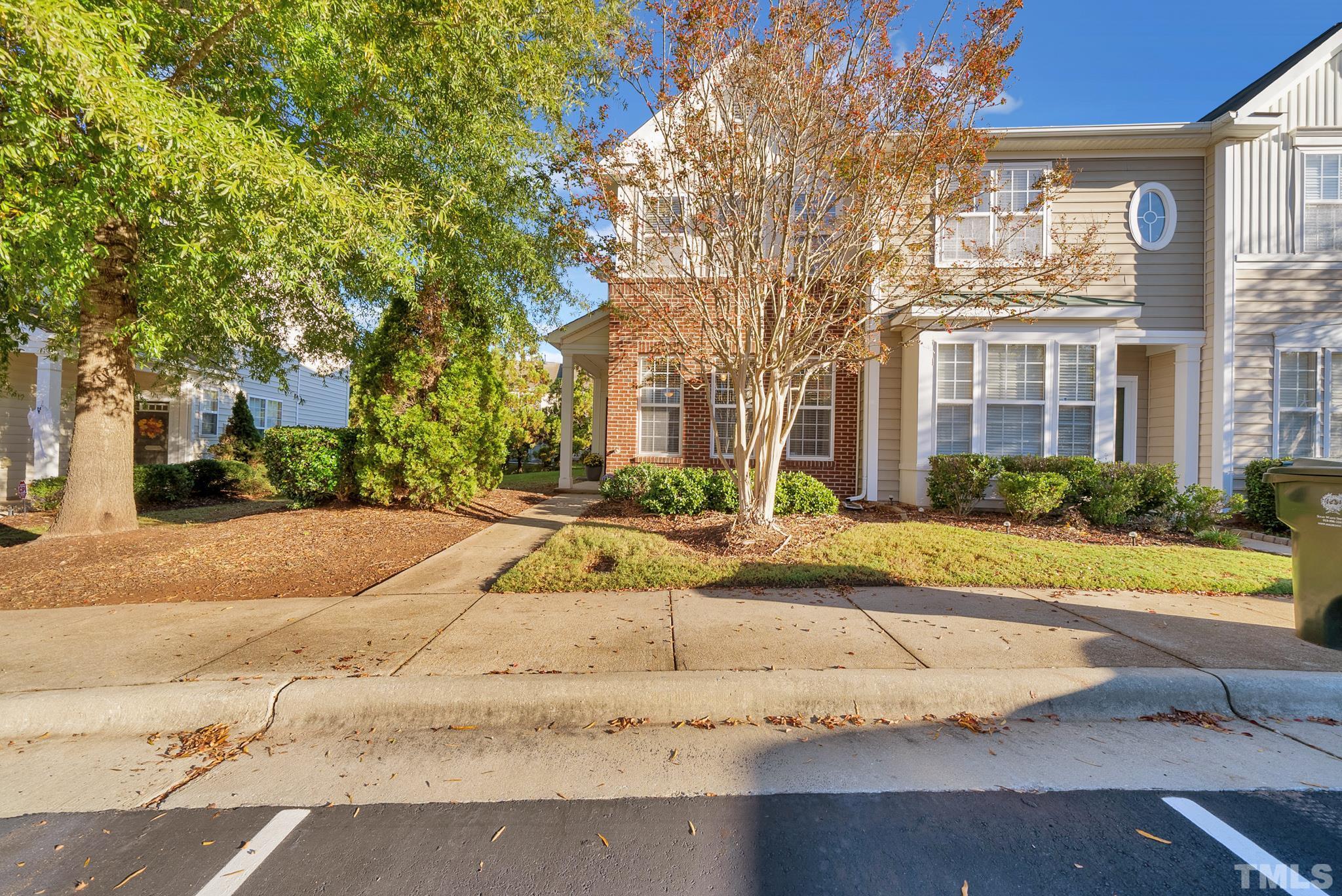 7618 Winners Edge Street Raleigh, NC 27617 - Photo 22 of 22 a view of a brick house with many windows plants and large tree