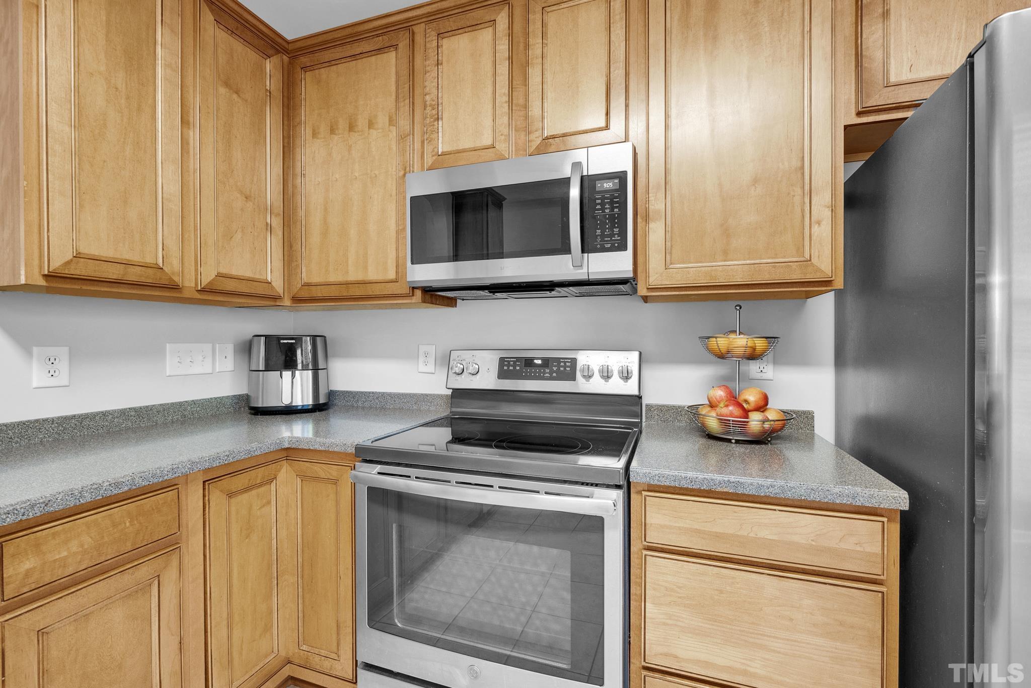7618 Winners Edge Street Raleigh, NC 27617 - Photo 9 of 22 a kitchen with stainless steel appliances a stove a microwave and cabinets