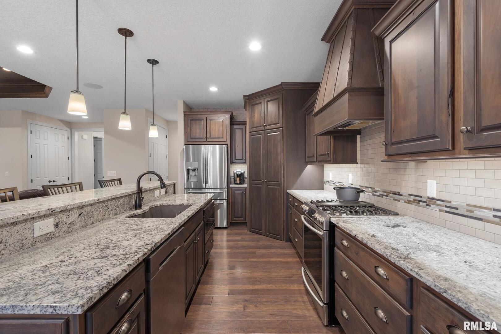 1422 Racine Court Davenport, IA 52804 - Photo 12 of 53 a kitchen with stainless steel appliances granite countertop a sink a stove top oven a counter space and cabinets