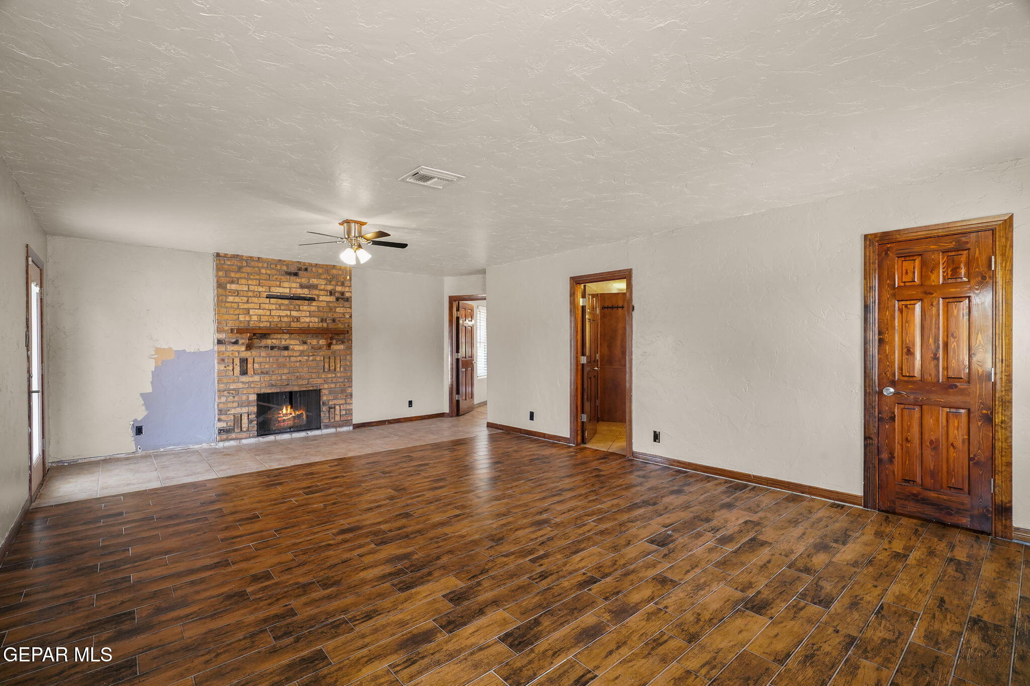5300 Crawford Road Santa Teresa, NM 88008 - Photo 32 of 87 an empty room with wooden floor and fireplace