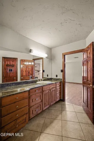 a bathroom with a granite countertop sink a toilet a mirror and bathtub