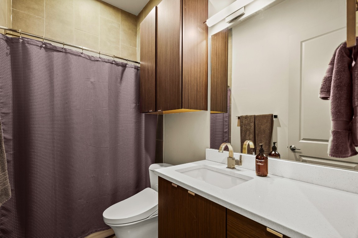 3005 East Martin Luther King Jr Boulevard Austin, TX 78702 - Photo 21 of 39 a bathroom with a granite countertop sink toilet and a mirror