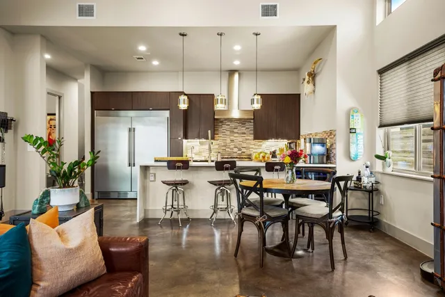 a kitchen with stainless steel appliances a stove a table and chairs