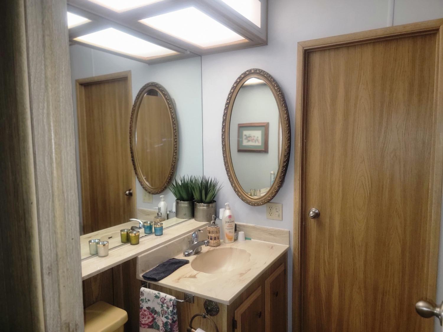 1300 West Olson Avenue, Unit 52 Reedley, CA 93654 - Photo 14 of 26 a bathroom with a sink and a mirror