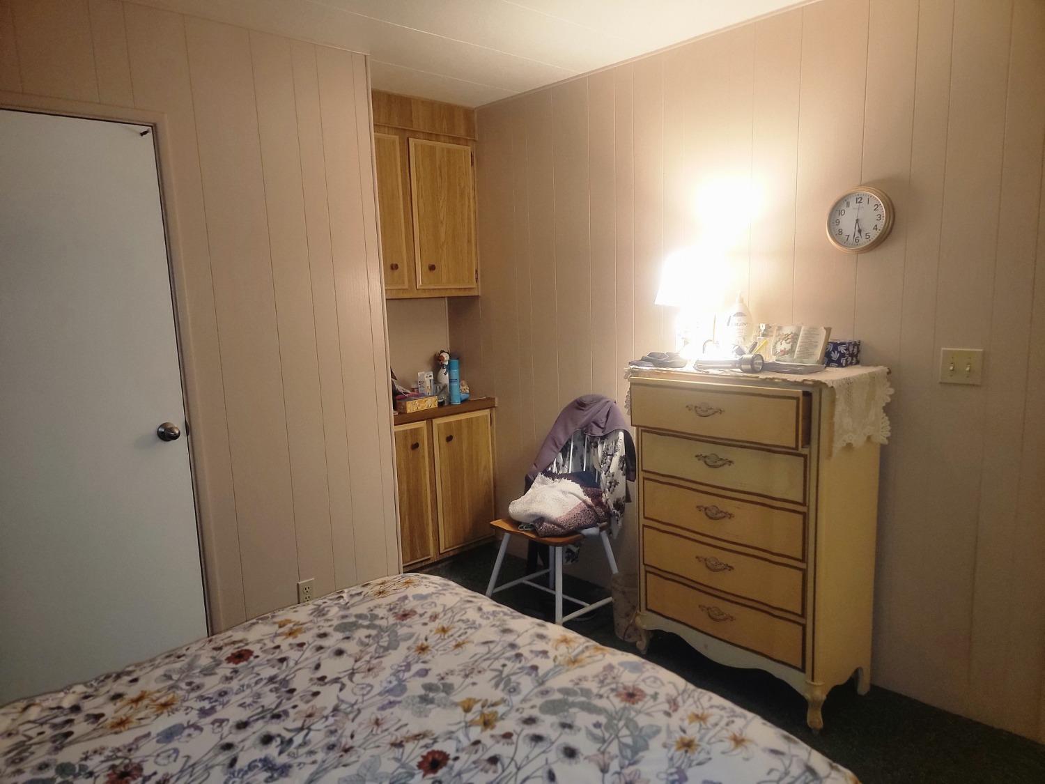 1300 West Olson Avenue, Unit 52 Reedley, CA 93654 - Photo 16 of 26 a bedroom with a bed and chair