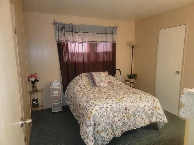 a bed sitting in a bedroom next to a window