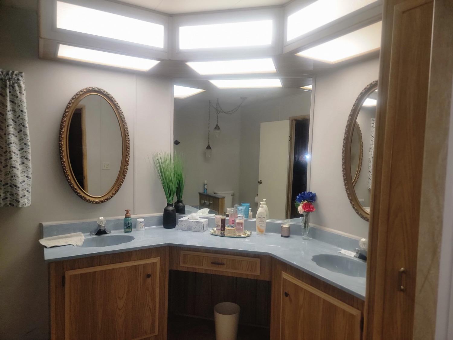 1300 West Olson Avenue, Unit 52 Reedley, CA 93654 - Photo 19 of 26 a bathroom with a double vanity sink and a mirror