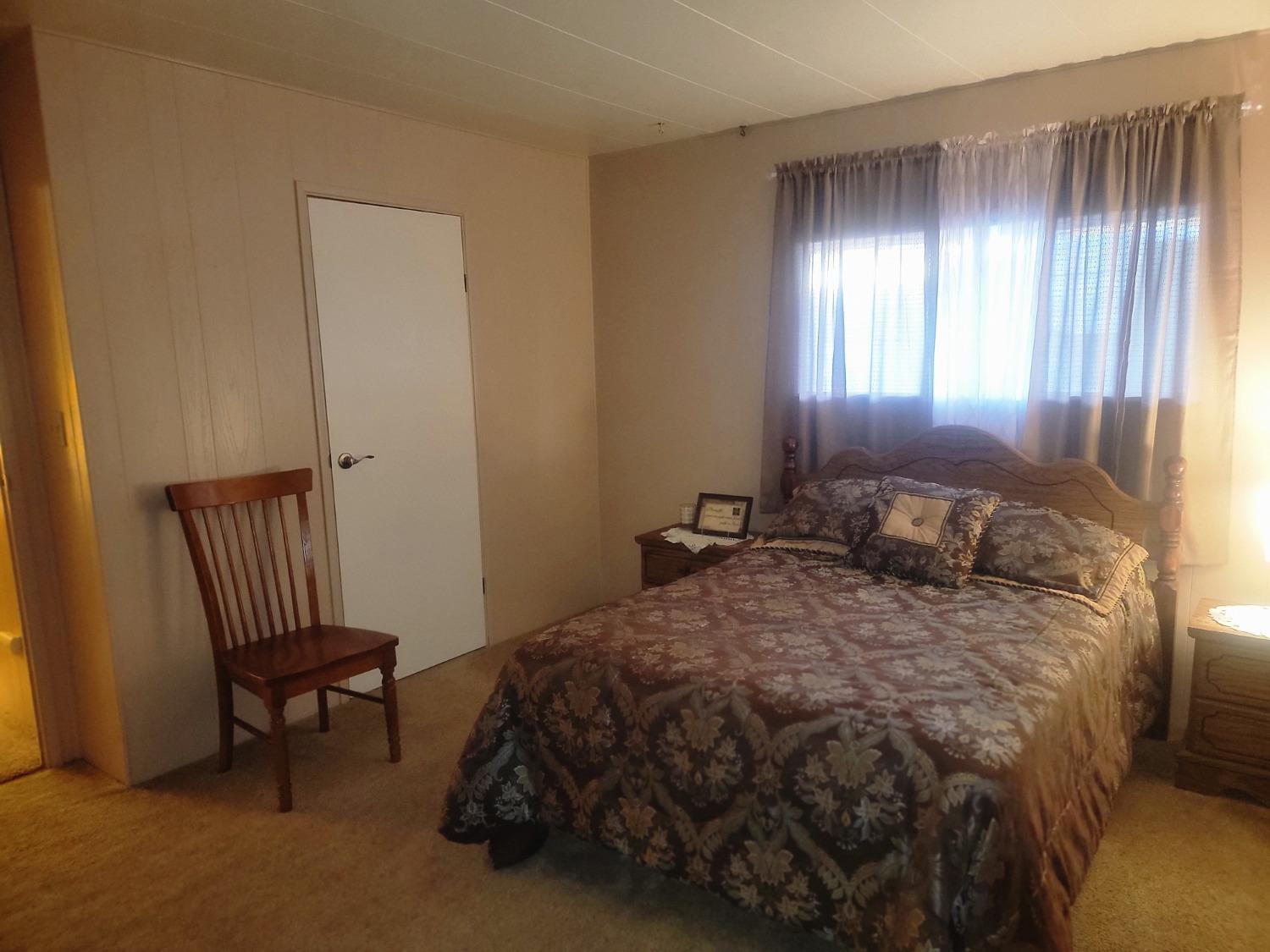 1300 West Olson Avenue, Unit 52 Reedley, CA 93654 - Photo 20 of 26 a bedroom with a bed and a window