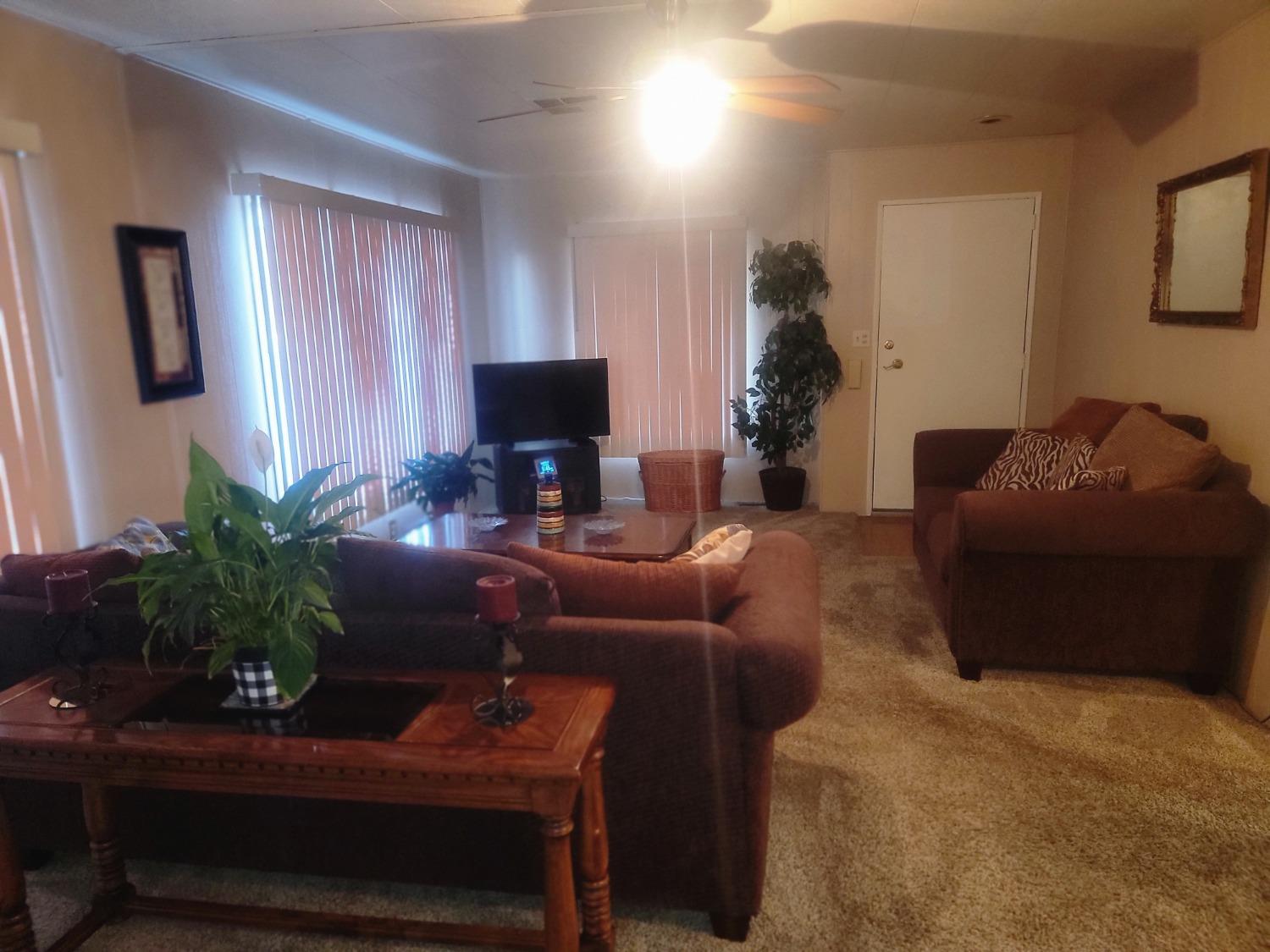 1300 West Olson Avenue, Unit 52 Reedley, CA 93654 - Photo 3 of 26 a living room with furniture a potted plant and a fireplace