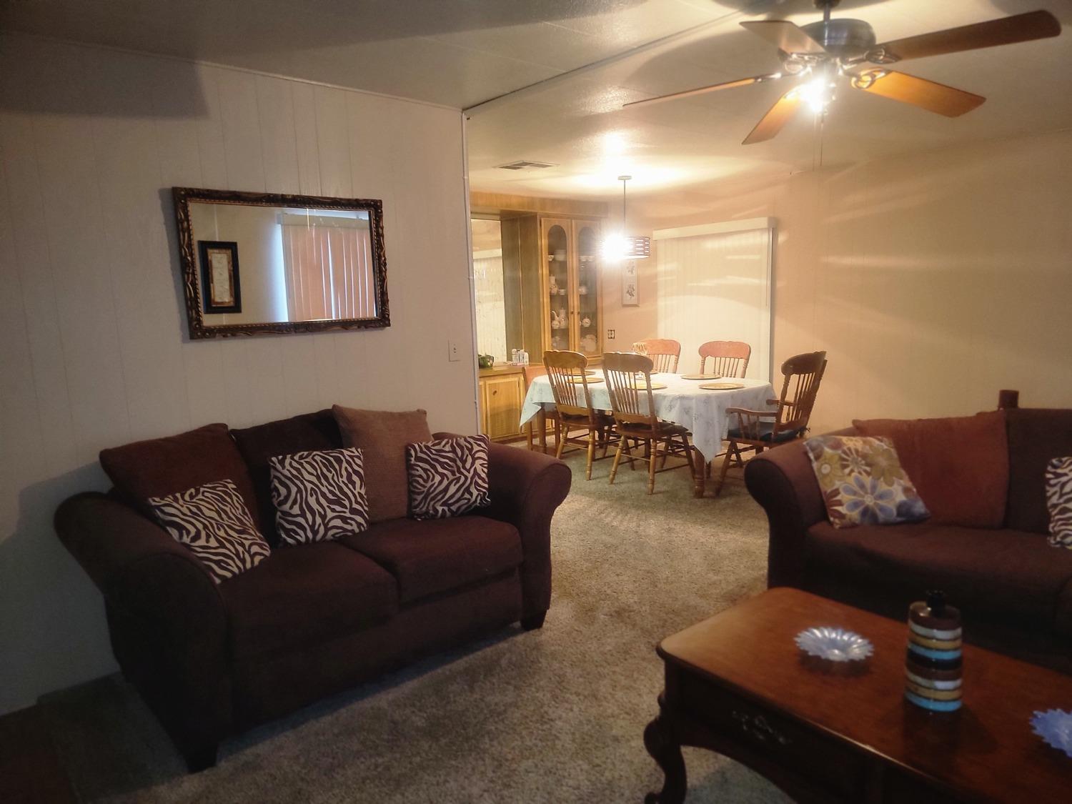 1300 West Olson Avenue, Unit 52 Reedley, CA 93654 - Photo 5 of 26 a living room with furniture and a large mirror
