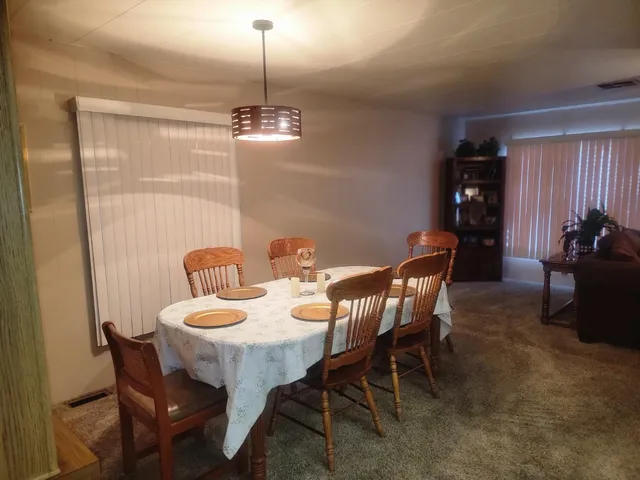 a view of a dining room with furniture wooden floor and chandelier