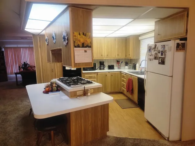 a kitchen with a refrigerator a stove a sink and a dining table