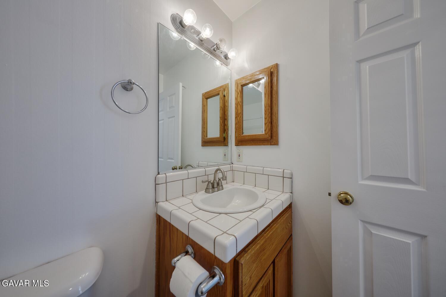 26801 Cabriolet Court Tehachapi, CA 93561 - Photo 35 of 60 a bathroom with a granite countertop sink a toilet and a mirror