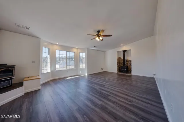 a view of a livingroom with wooden floor and a ceiling fan