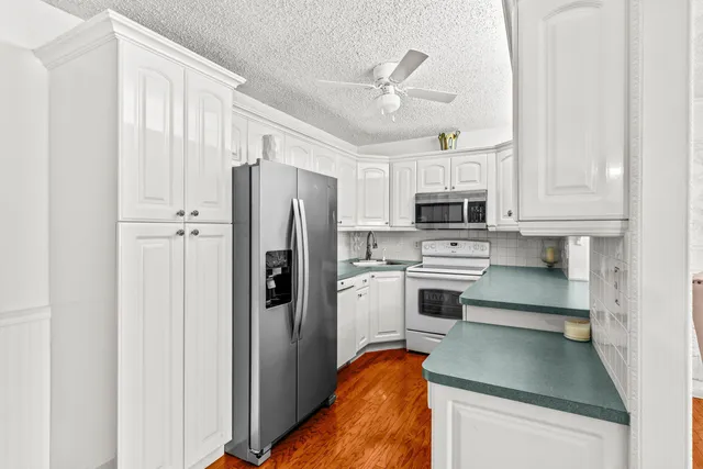 a kitchen with stainless steel appliances a refrigerator a stove a microwave and cabinets