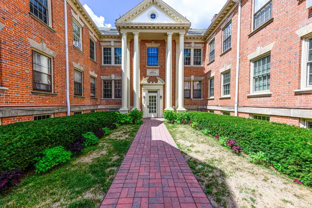a view of a brick building next to a yard