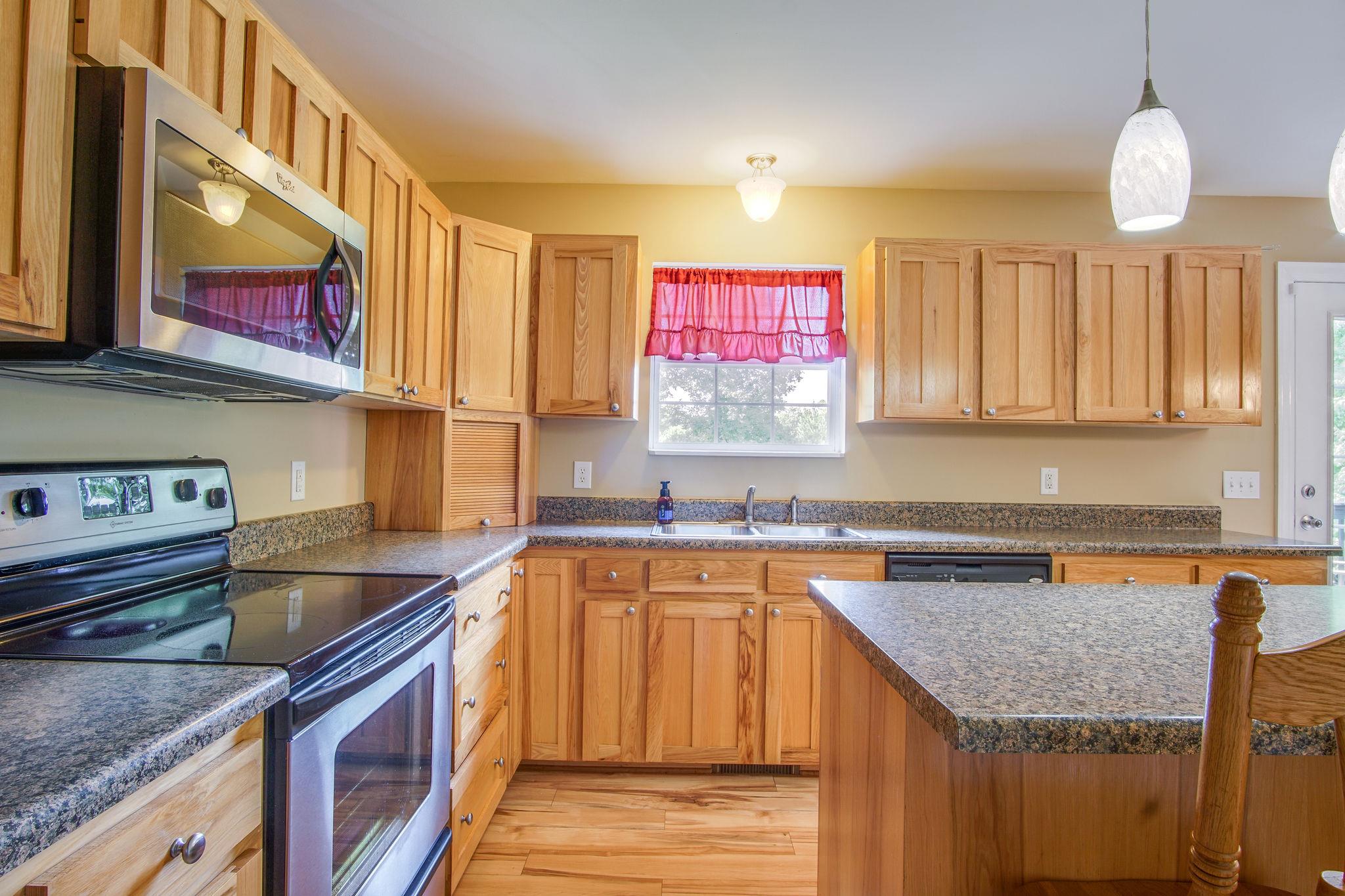 1674 Eno Road Dickson, TN 37055 - Photo 12 of 28 a kitchen with stainless steel appliances granite countertop a sink a stove and a microwave