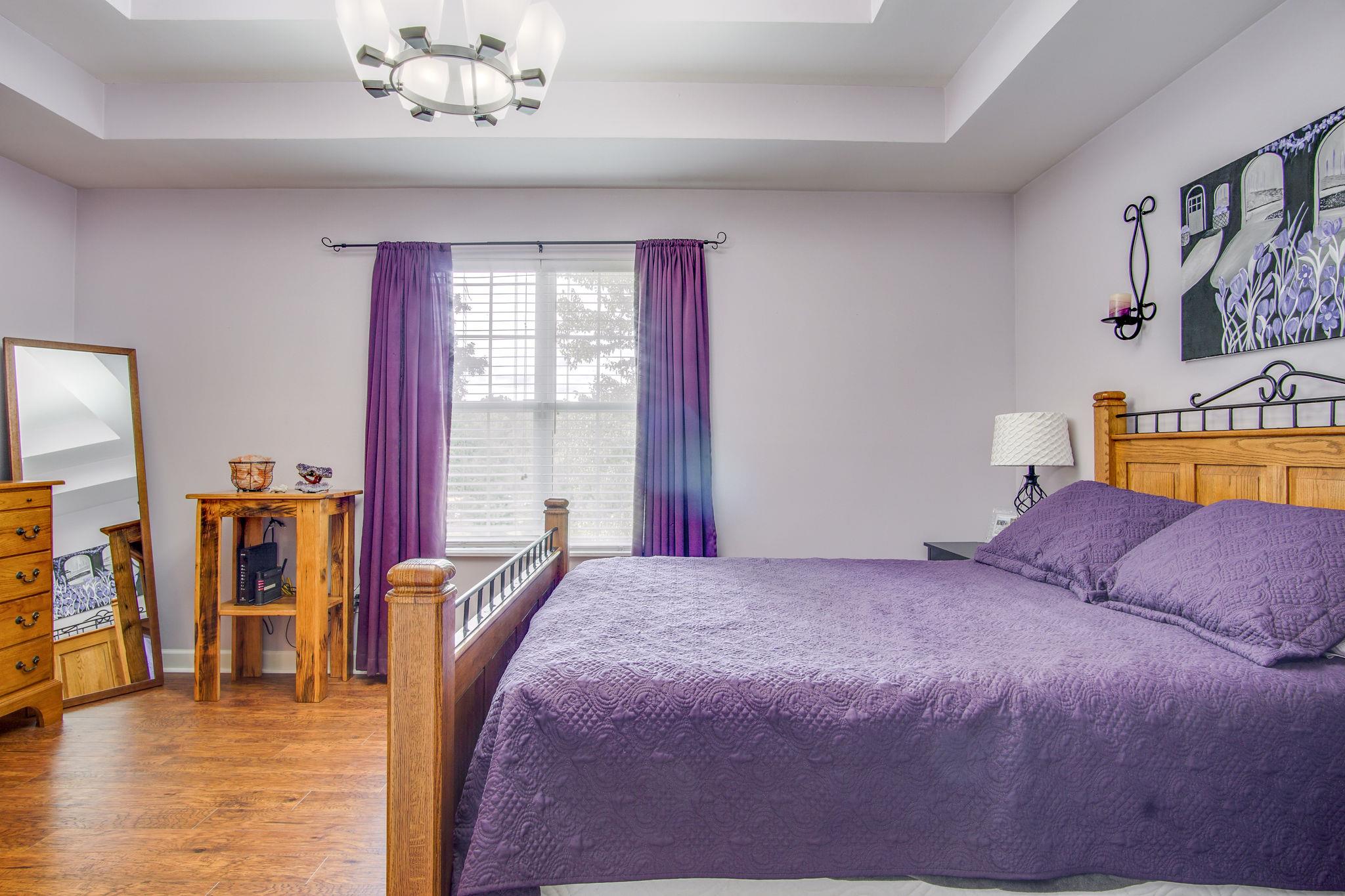 1674 Eno Road Dickson, TN 37055 - Photo 16 of 28 a bedroom with a large bed and a chandelier