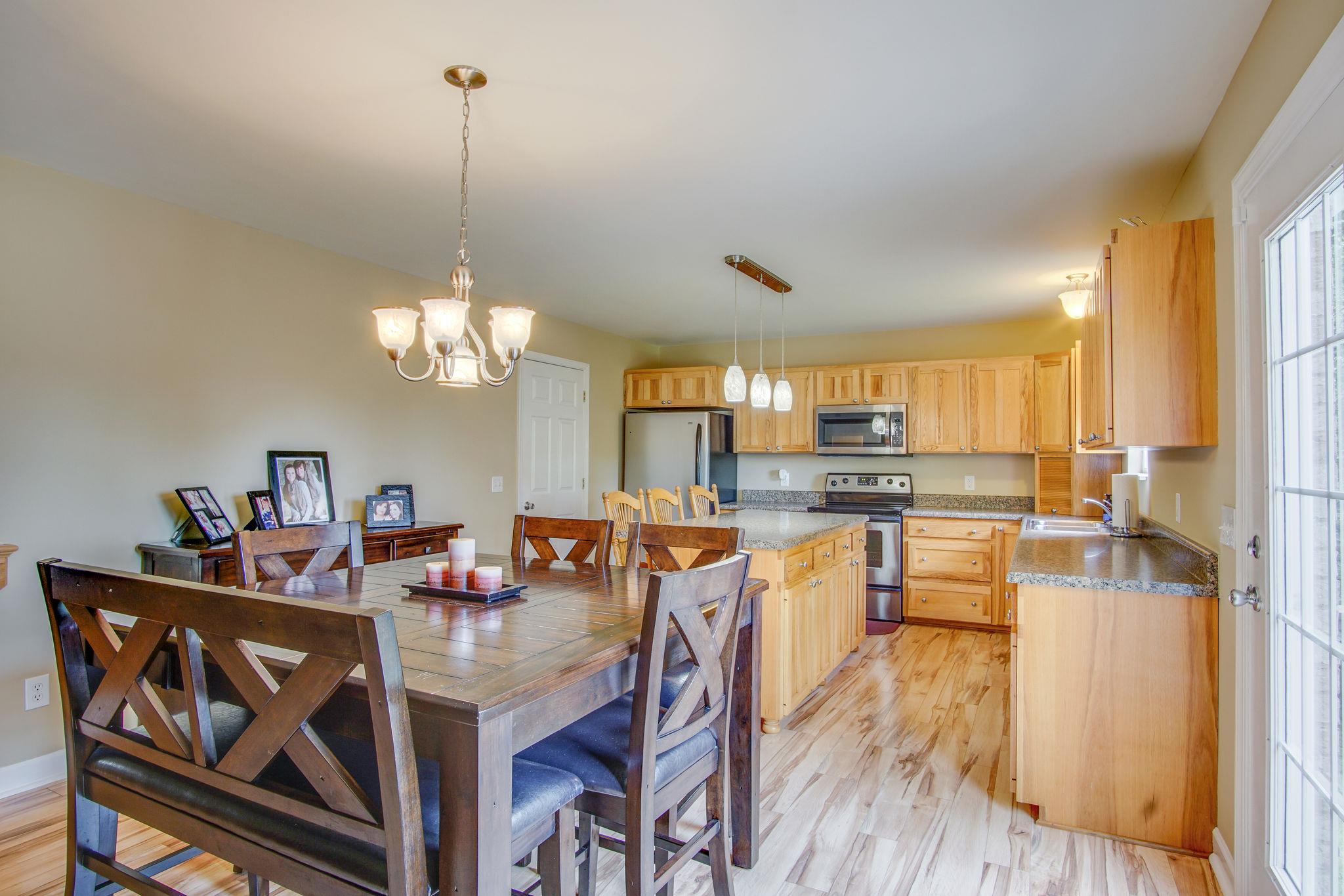1674 Eno Road Dickson, TN 37055 - Photo 9 of 28 a view of a dining room and livingroom with furniture wooden floor a chandelier
