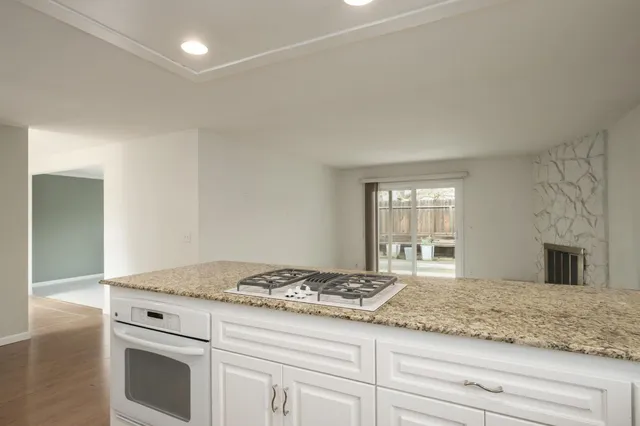 a kitchen with granite countertop cabinets stove and sink