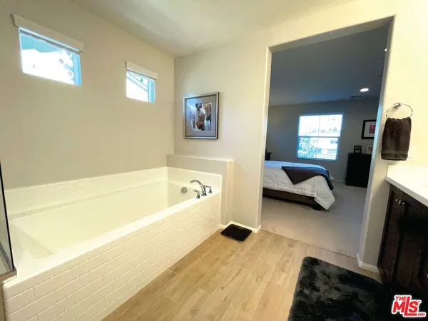 a en suite bathroom with a double vanity sink tub and mirror