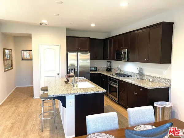 a kitchen with stainless steel appliances kitchen island granite countertop a sink stove and refrigerator