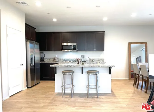 a kitchen with stainless steel appliances kitchen island granite countertop a sink and cabinets