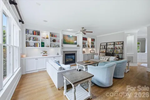 a living room with furniture a fireplace and a large window