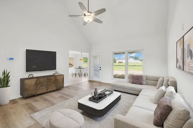 a kitchen with stainless steel appliances granite countertop a sink dishwasher a stove and a refrigerator with wooden floor