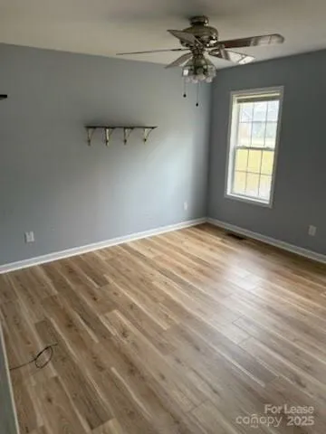 an empty room with wooden floor and entrance